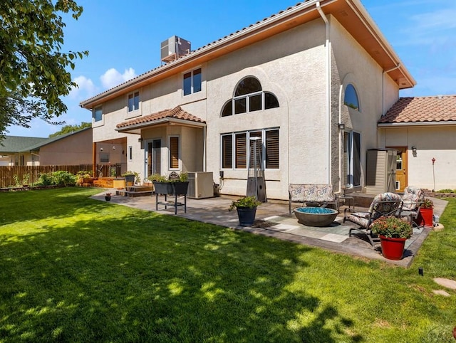 back of house with a yard, central AC unit, a patio, and stucco siding