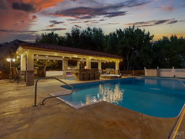 view of swimming pool with a fenced in pool, a patio, outdoor dry bar, and fence