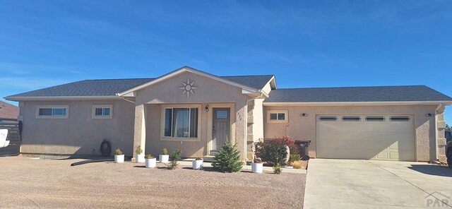 ranch-style home with a garage, driveway, and stucco siding