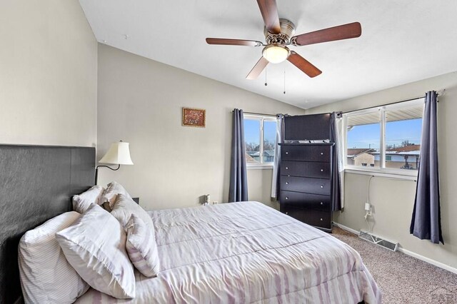 bedroom with baseboards, visible vents, ceiling fan, vaulted ceiling, and carpet flooring