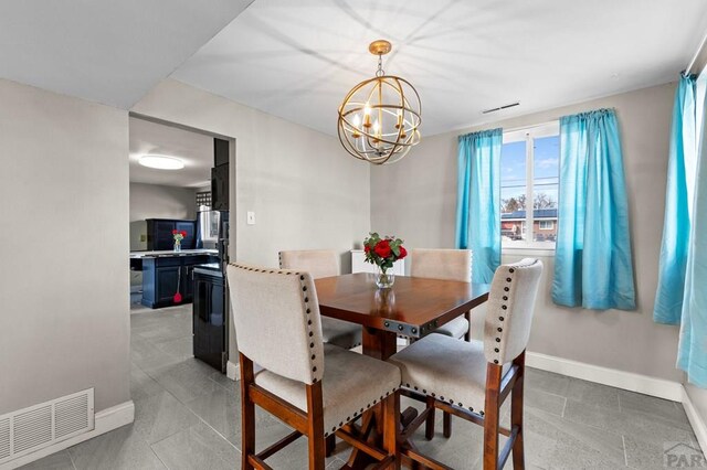 dining space featuring a chandelier, visible vents, baseboards, and light tile patterned floors