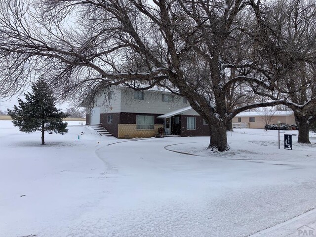 view of front of property featuring a garage and brick siding