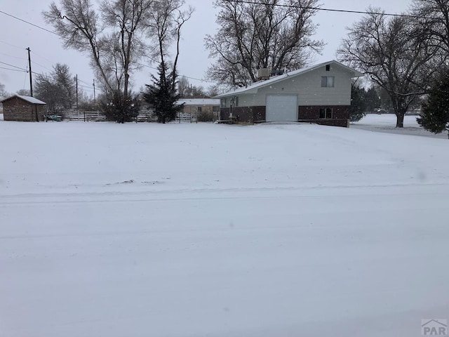 yard layered in snow with an attached garage