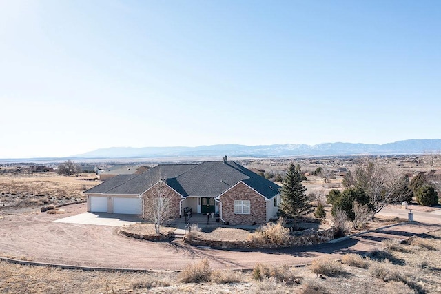 view of front of property featuring a garage, a mountain view, and concrete driveway