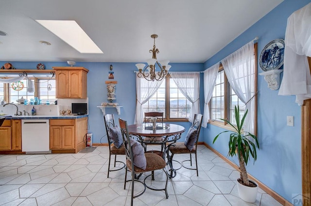 dining room with light tile patterned floors, plenty of natural light, a skylight, and an inviting chandelier