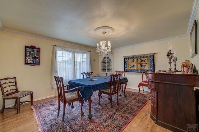 dining space with light wood finished floors and crown molding