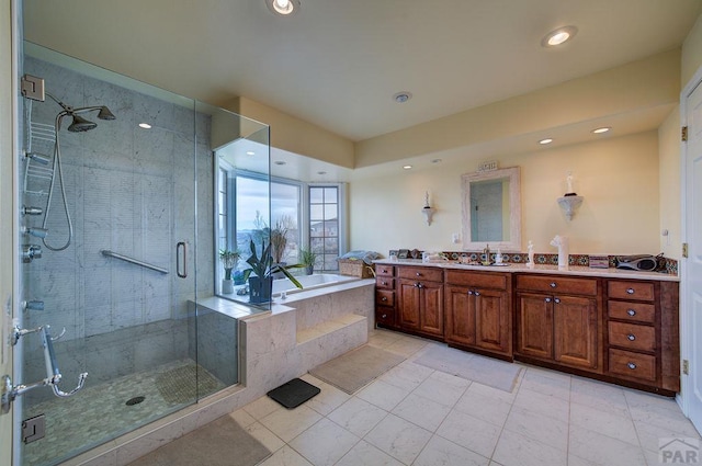 full bath featuring vanity, a shower stall, a bath, and recessed lighting