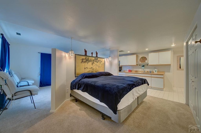 bedroom featuring baseboards, recessed lighting, a sink, and light colored carpet