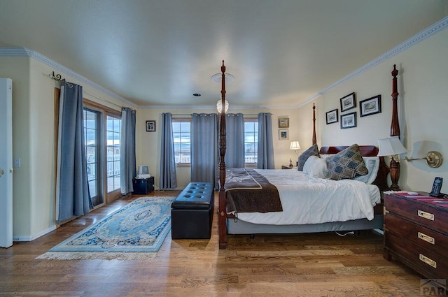 bedroom with crown molding, access to outside, and wood finished floors