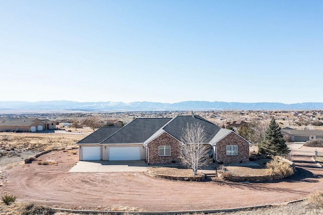 ranch-style home with a garage, a mountain view, and concrete driveway