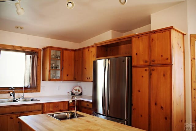 840 County Rd 627, Gardner, CO 81040 - kitchen with freestanding refrigerator, a sink, brown cabinetry, and glass insert cabinets