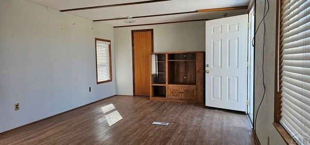 unfurnished bedroom featuring dark wood-style floors and visible vents