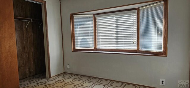 unfurnished bedroom with multiple windows and a closet