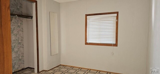 unfurnished bedroom with light floors and a closet