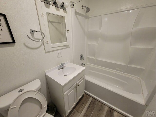 bathroom with vanity, wood finished floors, toilet, and shower / bathtub combination with curtain