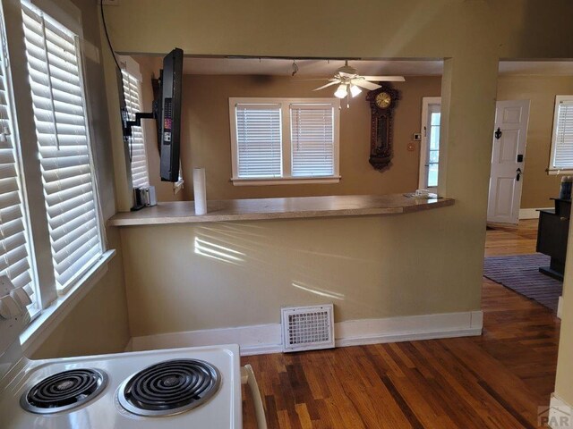 kitchen with baseboards, visible vents, a ceiling fan, dark wood finished floors, and electric stove