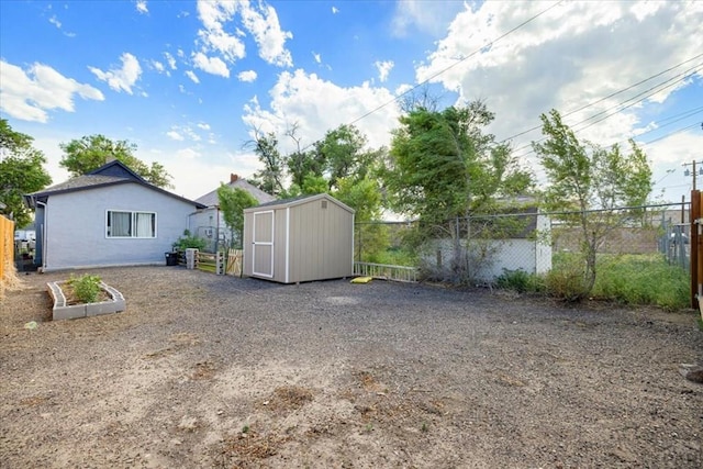 view of yard with fence, an outdoor structure, and a shed