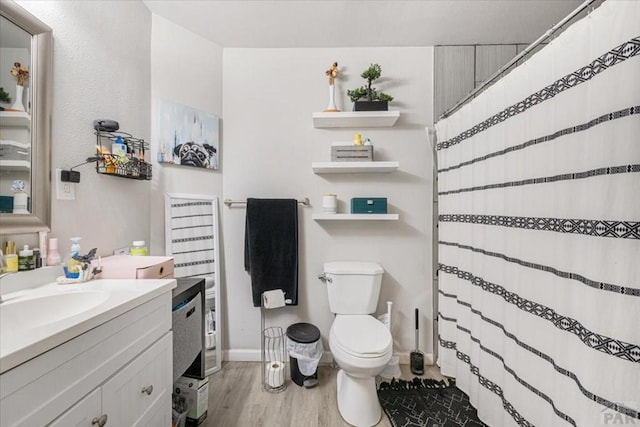 bathroom with wood finished floors, vanity, a shower with shower curtain, and toilet