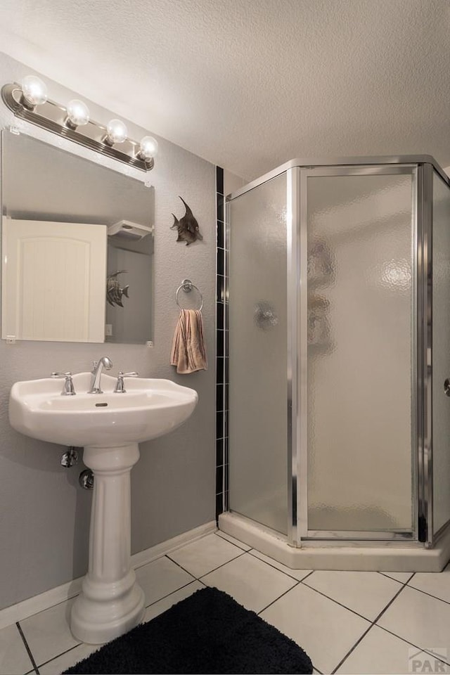 477 S Venango Dr, Pueblo West, CO 81007 - full bathroom with a stall shower, tile patterned floors, a textured ceiling, and baseboards