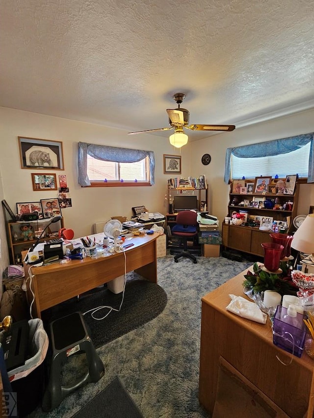 carpeted office space featuring a textured ceiling and a ceiling fan