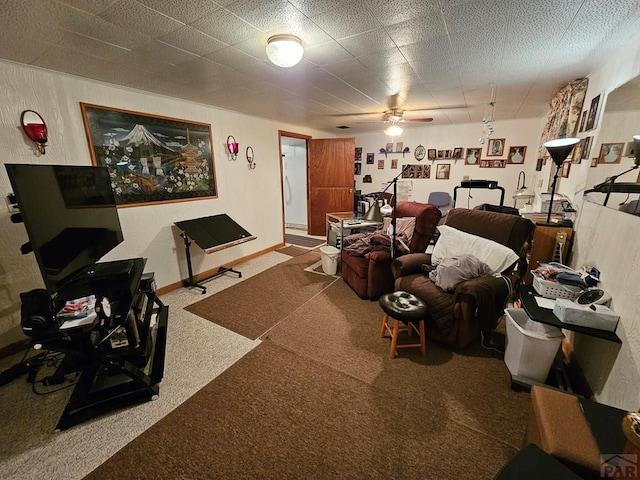 living area featuring baseboards, carpet, and a ceiling fan