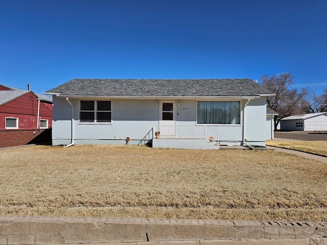 view of front of property with a front lawn and a shingled roof