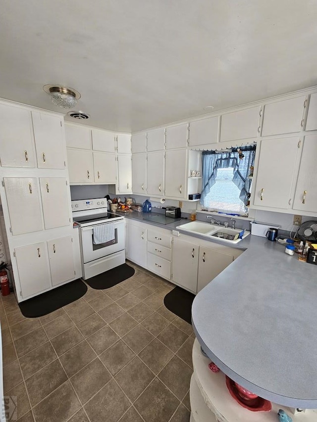 kitchen with white electric range oven, visible vents, a sink, white cabinets, and dark tile patterned floors