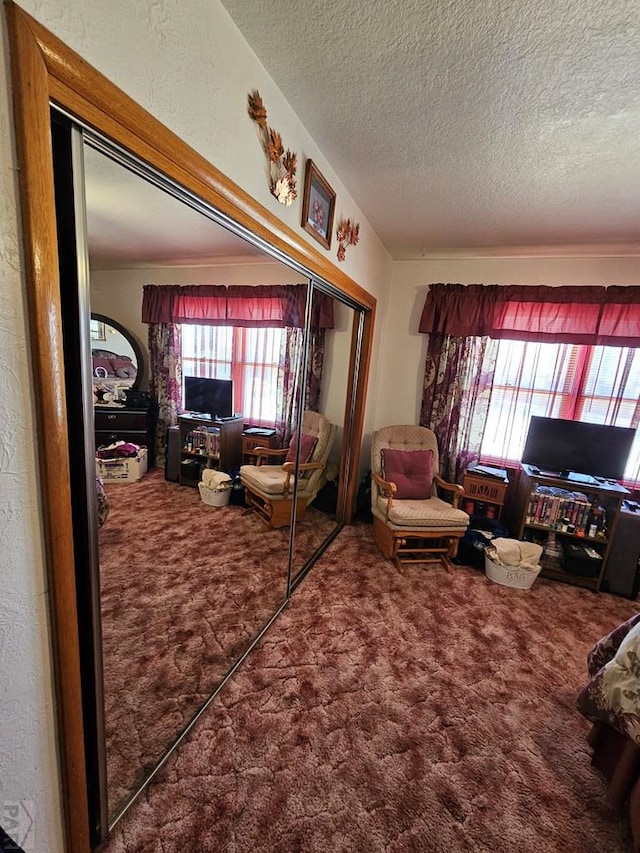 bedroom with a closet, a textured ceiling, and carpet floors