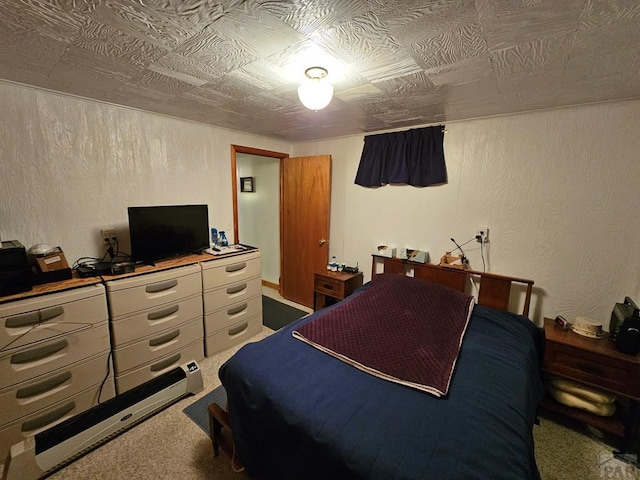 carpeted bedroom with an ornate ceiling and a textured wall