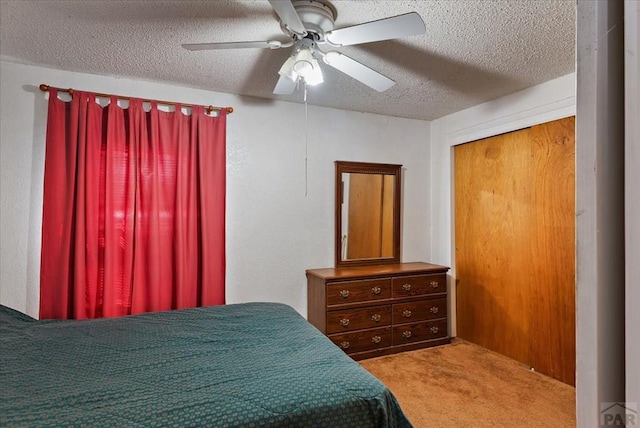 bedroom featuring light carpet, ceiling fan, and a textured ceiling