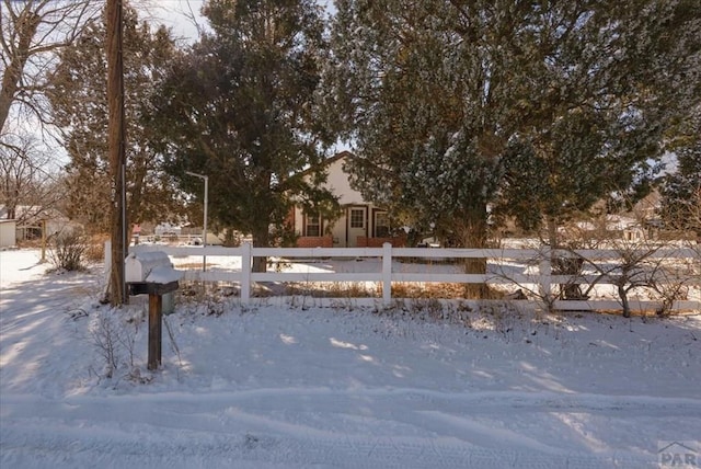 yard covered in snow featuring fence