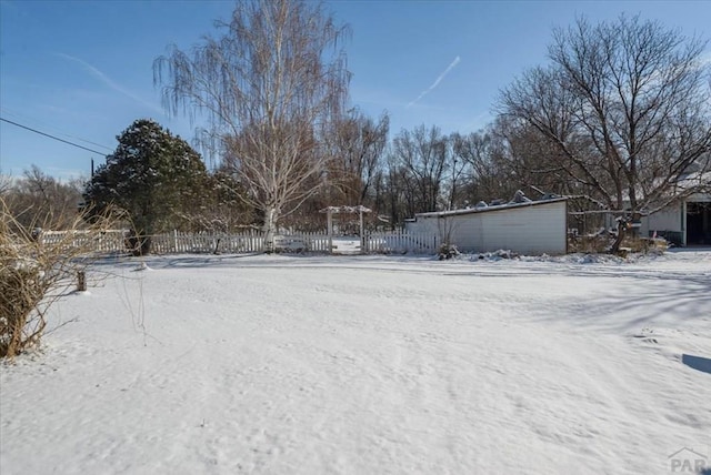 yard covered in snow featuring fence