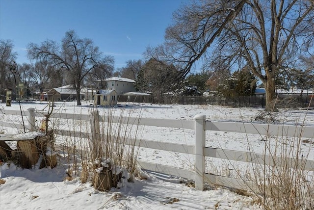 yard covered in snow featuring fence