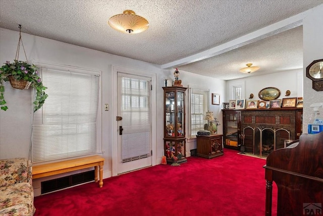 entryway with a textured ceiling, a brick fireplace, and carpet flooring