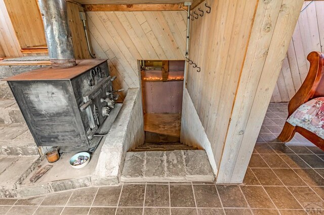 staircase featuring wood walls and a wood stove