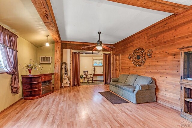 living room with a healthy amount of sunlight, wood walls, and light wood-style flooring