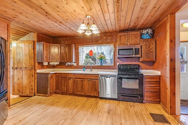 kitchen with visible vents, appliances with stainless steel finishes, brown cabinets, decorative light fixtures, and light countertops