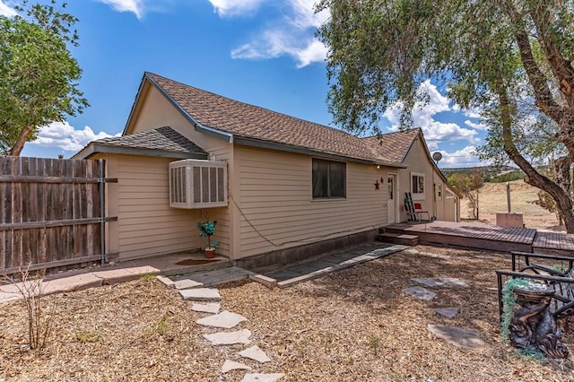 view of side of property with fence and a deck