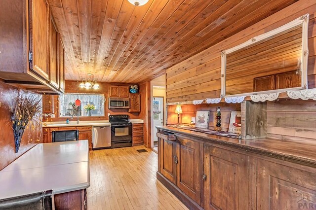 kitchen featuring wooden ceiling, stainless steel appliances, brown cabinets, light wood finished floors, and pendant lighting