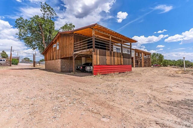 view of outbuilding featuring a carport, an outbuilding, and an exterior structure