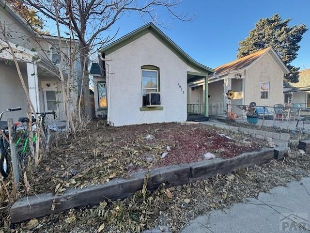 view of front of house featuring cooling unit, fence, and stucco siding