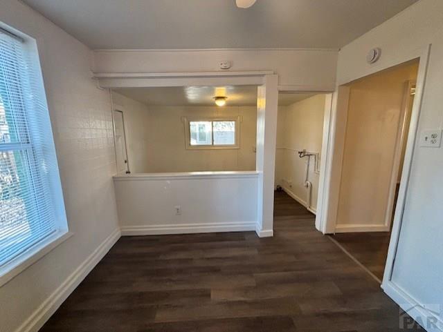 unfurnished room featuring dark wood finished floors and baseboards