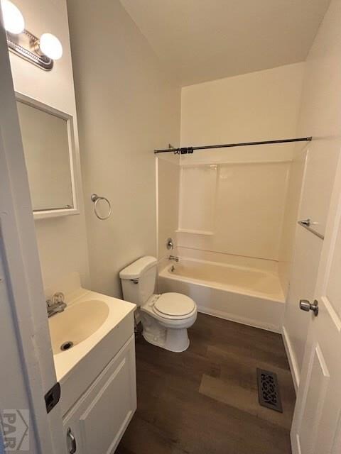 bathroom with visible vents, toilet, wood finished floors, vanity, and washtub / shower combination