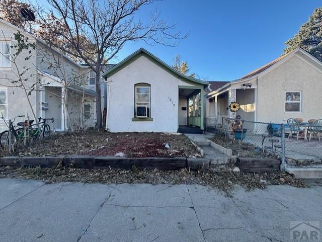 view of front of house with fence and stucco siding