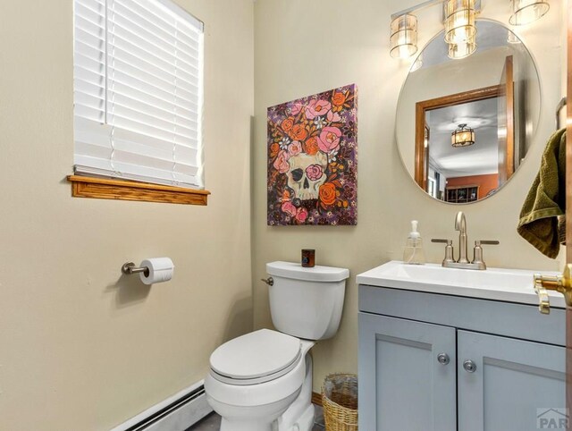 half bathroom featuring a baseboard radiator, vanity, and toilet