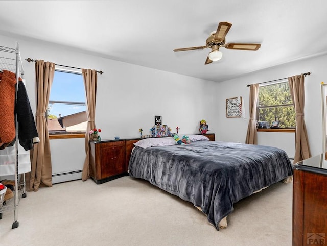 bedroom with a baseboard radiator, ceiling fan, and light colored carpet