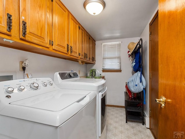 clothes washing area featuring light floors, washer and clothes dryer, cabinet space, and baseboards