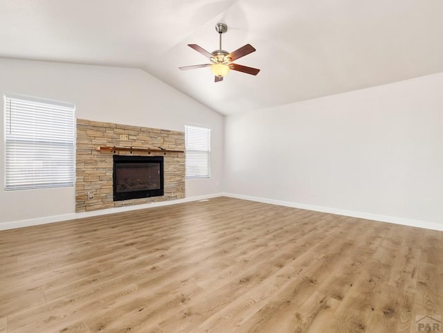 unfurnished living room with lofted ceiling, light wood-style floors, ceiling fan, and a fireplace