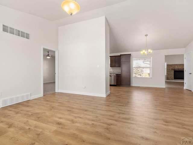 unfurnished living room featuring high vaulted ceiling, light wood-type flooring, visible vents, and baseboards