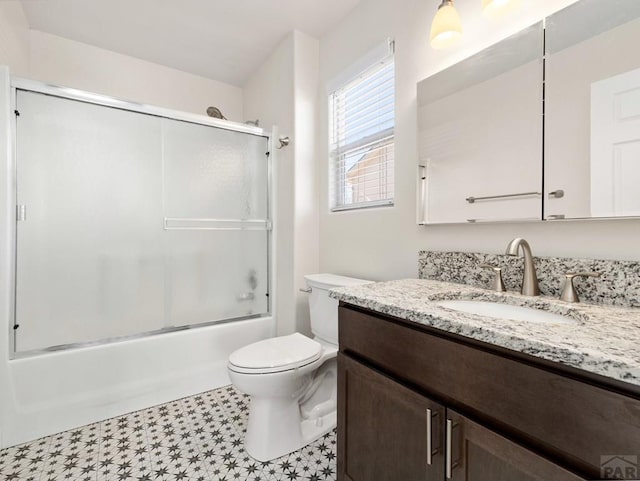 full bathroom featuring shower / bath combination with glass door, vanity, and toilet